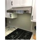 GE 24 inch stainless steel under cabinet range hood installed above stove with kitchen cabinets